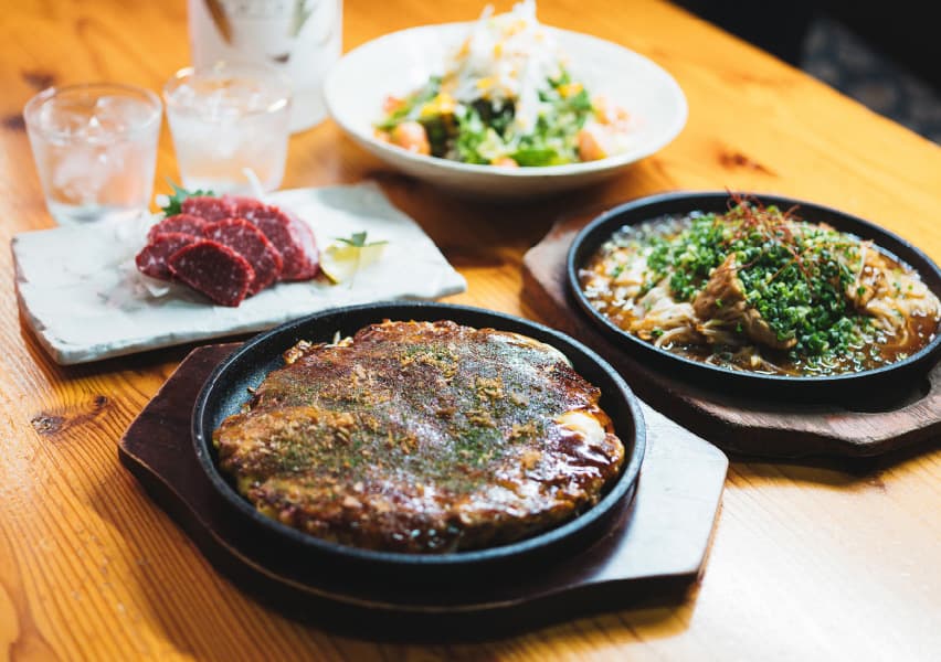 写真：鉄板皿に乗ったお好み焼きや馬刺しなど