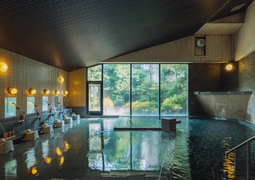 写真：広い湯船と大きなガラス、洗い場がたくさんある内風呂